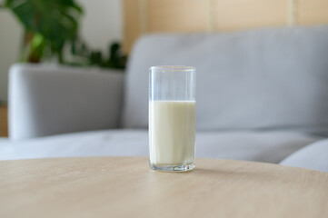 A glass of milk in modern living room with houseplant
