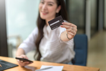 Young Asian businesswoman enjoy shopping online using credit card at office.