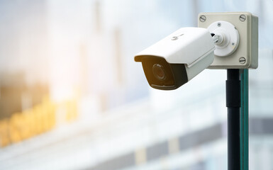 Modern public CCTV camera on blur building background. Recording cameras for monitoring all day and night. Concept of surveillance and monitoring with copy space.