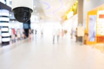 Modern public CCTV camera with blur interior shopping mall background. Recording cameras for...