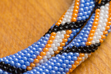 Beading as hobby and needlework. Ethnic bead pattern. Handmade necklace element.