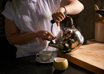 Brewing the perfect cup. Cropped shot of a young woman making a cup of tea in her kitchen.