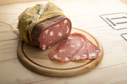Spinata Salami in cloth served on a wooden plate
