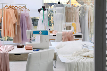 Obraz na płótnie Canvas Dressmaking workshop interior with wedding dresses and equipment