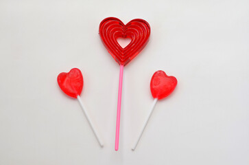 three heart shaped lollipops on white background