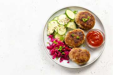 Healthy meal, rissoles, sauerkraut, cucumber salad, ketchup. Top view, copy space.