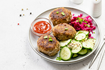 Fried beef rissoles,red cabbage salad, cucumber salad, ketchup. Top view, copy space.