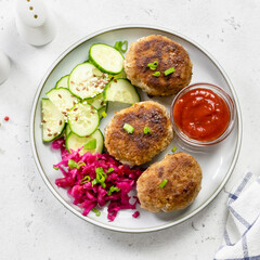 Turkey fried patties, sauerkraut, cucumber salad, ketchup. Top view, copy space.