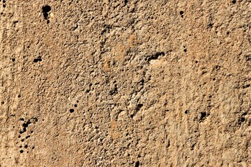 Old gray brown irregular concrete wall as background