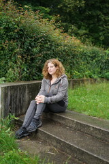 Frau sitzt alleine auf Treppe im Park