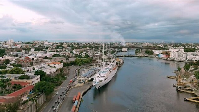 MSY Wind Surf ship moored in Colonial zone port at sunset with Santo Domingo city in background. Aerial panoramic view