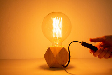 Tungsten light bulb lamp cozy turning on by a hanover white background