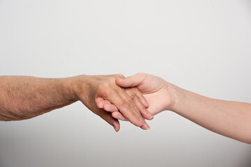 hand of a young man supporting the hand of an old woman
