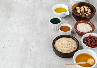 Assorted superfoods over stone background with copy space. Chia, quinoa, oat, linseed, honey, spirulina and others