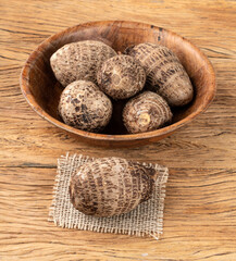 Raw yams or inhames on a bowl over wooden table with copy space