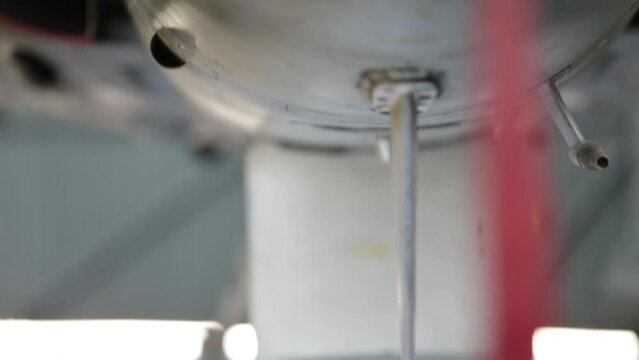 Air Force Jet Fighter in Hangar, Red Ribbon on Jet Fighter Pitot Tube Cover. Close Up.