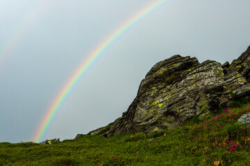 Rainbow in the rainy sky over the Carpathians. Ukraine.