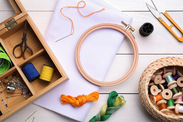 Set of embroidery equipment on white wooden table, flat lay