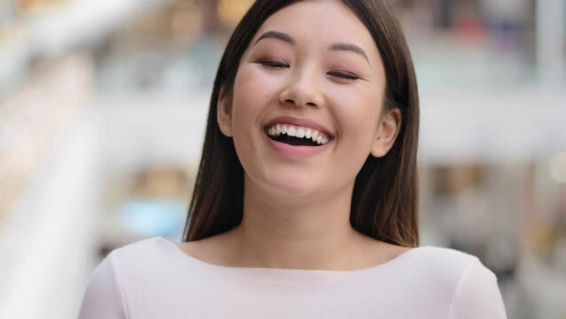 Cheerful happy funny female face asian dent girl model laughing emotion joke satisfied looking at camera having fun great sense of humor making pleasure atmosphere woman having joyful carefree mood