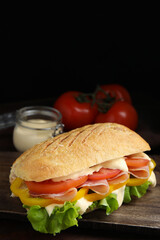 Delicious sandwich with vegetables, ham and mayonnaise on wooden table