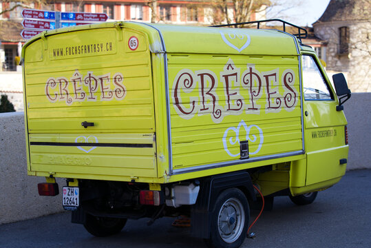 Yellow mobile crepes stand near the Laufen Castle at famous Rhine Falls on a sunny spring day. Photo taken March 5th, 2022, Laufen-Uhwiesen, Switzerland.