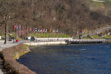 Flags of all Swiss Cantons at border of natural pool of famous Rhine Falls on s sunny spring day....