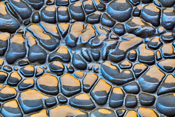 Wet cobblestone road as textured background