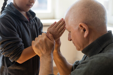 hands of grandfather and granddaughter with prayer