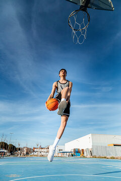 Faceless man throwing ball in hoop