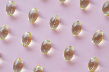 Vitamin E capsules pattern pink background 