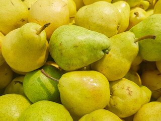 Food background yellow and green fresh ripe pears, close-up view from above, organic fruit concept
