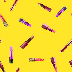Seamless pattern with lipstick on summer yellow background.