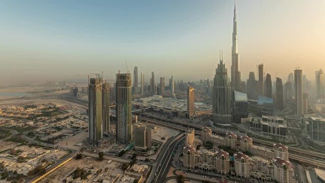 Panorama showing aerial view of tallest towers in Dubai Downtown skyline and highway timelapse.