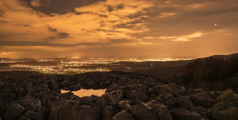 View from a rock to a illuminated city after sunset