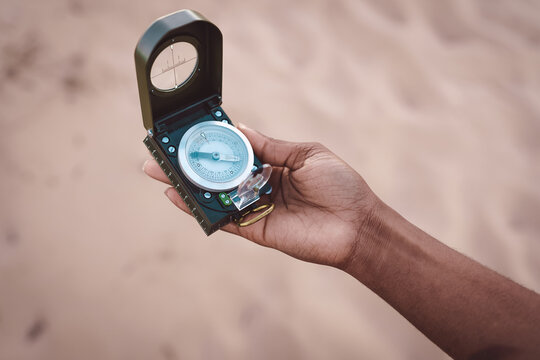 Black traveling woman with compass on seashore