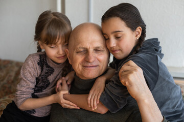 Fototapeta premium Ukrainian grandfather and two granddaughters hugging