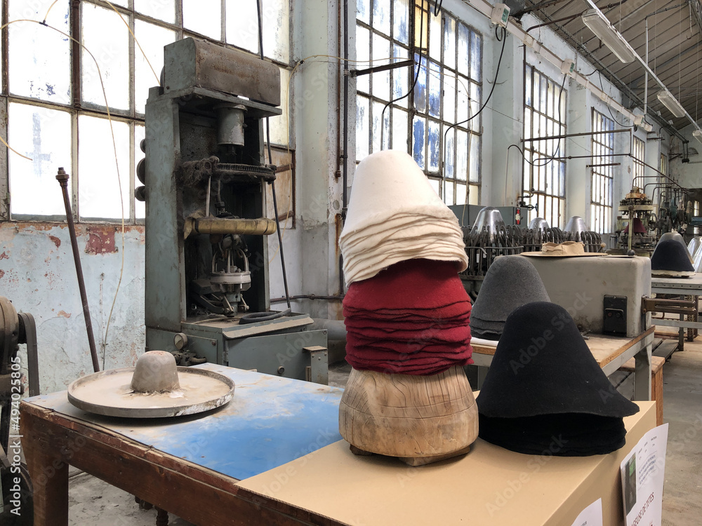 Poster shot of a stack of old style french hats on the table in an ancient hats factory