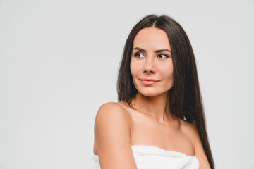 Pretty young caucasian woman in bath spa towel with clear skin and healthy hair taking care of her...