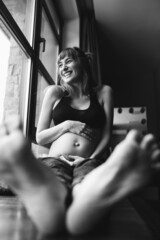 Pregnant woman sitting by the window