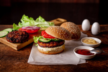 Home cooking hamburger or cheeseburger. Different ingredients for a classic hamburger. Wooden background. Food concept.