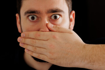 close up worried man with his hand to his mouth, Censorship and prohibitions, freedom of speech...