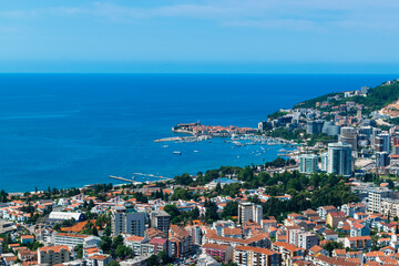 Fototapeta na wymiar Panoramic landscape of resort Budva city on blue sky background. Top view. The architecture of the old and new city, located on Adriatic coast. Montenegro.