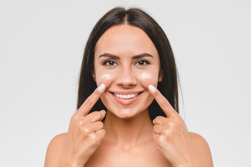 Cropped portrait of a young girl woman using softening moisturizing face cream for skin face care....
