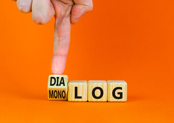 Businessman turns wooden cubes and changes the German word monolog - monologue in English to dialog - dialogue in English. Beautiful orange background. Business monolog or dialog concept. Copy space. - obrazy, fototapety, plakaty
