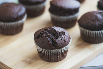 Chocolate muffins on a wooden board.