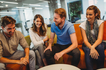 Group of happy multiethnic business people having fun and chatting at workplace office