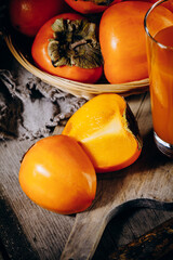 A group of ripe orange persimmon fruits.Persimmon fruits on a wooden board, rustic background