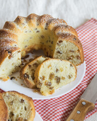 Round cake with raisins, cutted into pieces close-up. Selective focus
