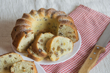 Round cake with raisins, cutted into pieces close-up. Selective focus