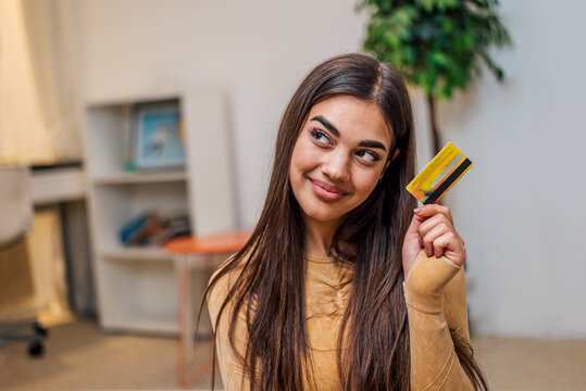 Delighted caucasian girl, holding credit card, going shopping.